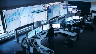 Meriliikennekeskus, jossa meriliikenneohjaaja katsoo seinällä avautuvaa isoa meriliikenteen tilannekuvaa.