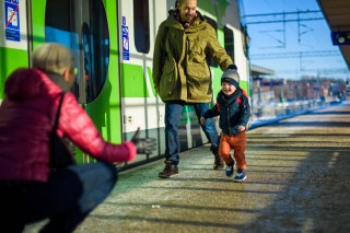 Lapsi juoksee junalaiturilla naista vastaan.