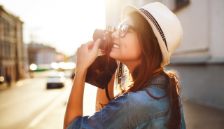 Nainen valokuvaamassa kaupunkinäkymää kesällä