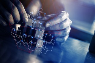 Kädet rakentamassa palikoista