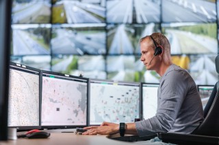 Liikenneoperaattori päätteellä tieliikennekeskuksen salissa