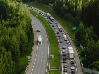 Ylhäältä otettu kesäinen kuva Suomen valtatiestä, jossa paljon autoja liikkeellä.