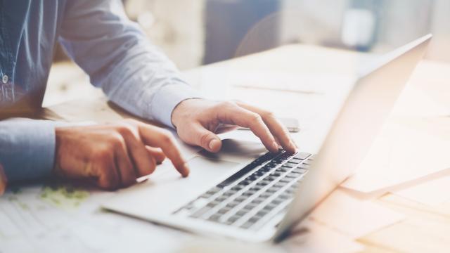 Mies läppärillä, lähikuva käsistä