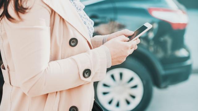 Nainen katsoo kännykästä Fintraffic Mobiili sovellusta