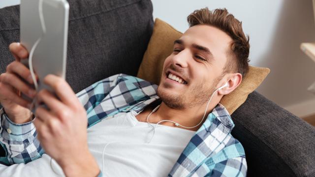 Mies katsoo tabletilta sohvalla Liikennetilanne-palvelua