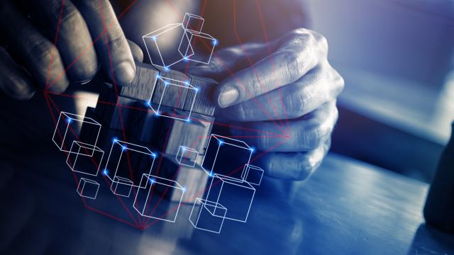 Kädet rakentamassa palikoista